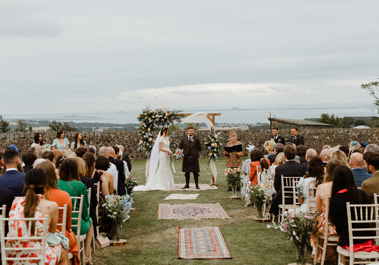 Outdoor ceremony with bride and groom at altar